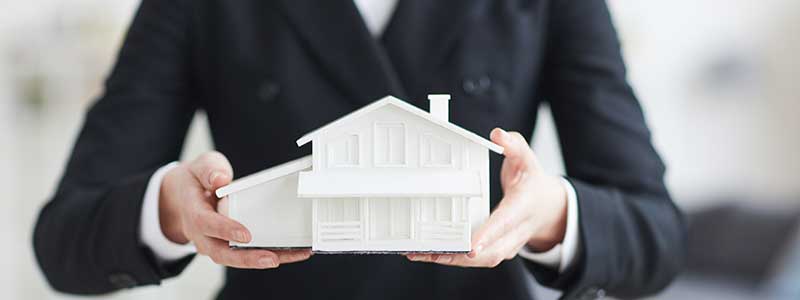 Mortgage information woman holds model of house